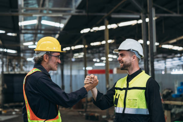 istock Team Engineer is shaking hands. Industrial worker in the factory. Engineer is maintaining in the warehouse. 1598125175