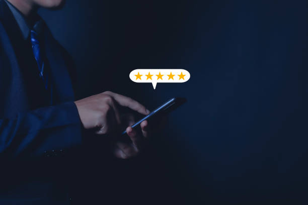 istock Close-up on customer hand pressing on smartphone screen with golden five star feedback icon and awesome rating for best rating 1598126768