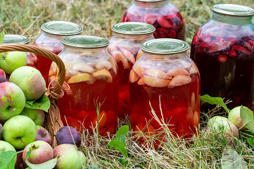 Apple compote in jars preserved for the winter. Fruit on the grass.