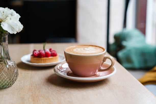 istock Orange cup with coffee and dessert on background 1598147864