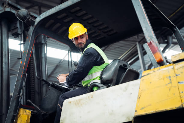 istock Industrious Engineer Operating Forklift in Warehouse. Efficient Forklift Driving in Factory. Engineer is working and maintaining in the factory. 1598157809