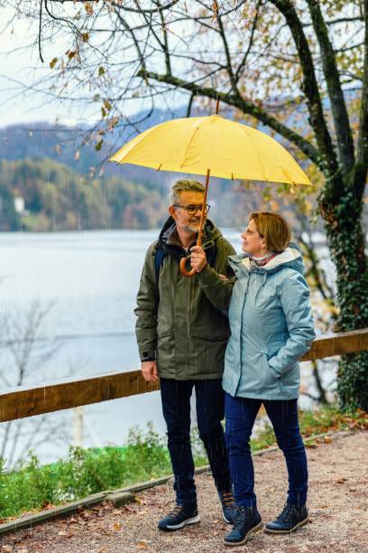 Mature couple enjoying a rainy day stock photo
