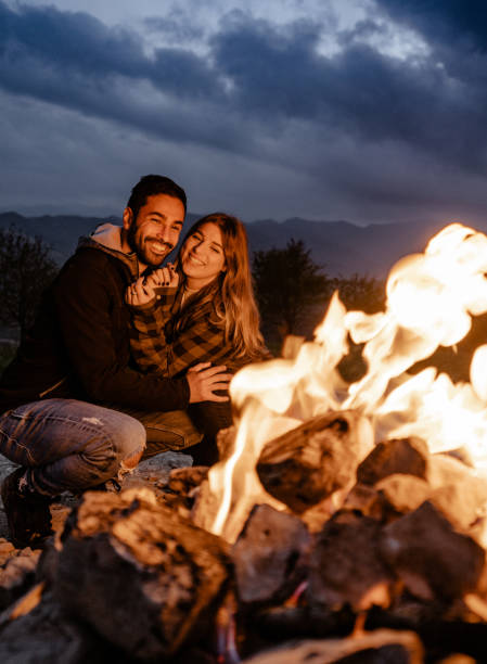 istock lovely passionate couple in front at the fire camping 1598185556