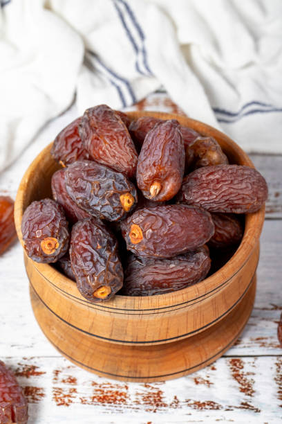 istock Date fruit in wood bowl. Natural dates on a white wood background 1598186099