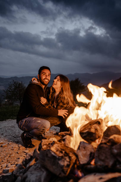 istock lovely passionate couple in front at the fire camping 1598187693