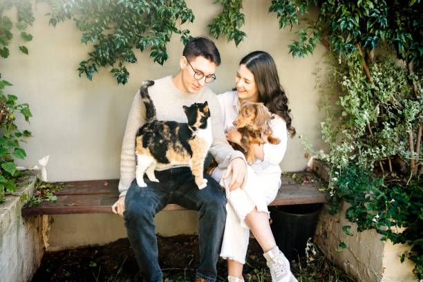 Happy young couple relaxing in backyard with their pets