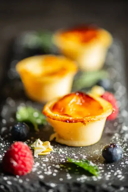 Homemade petite custard tart, also known as flan patissier or Parisian. A baked pastry with an outer sweet shortcrust pastry filled with egg custard.
