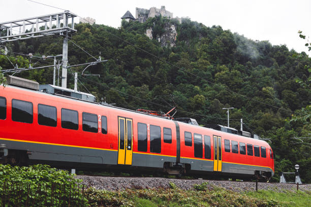 Electric passenger train drives at high speed among urban landscape