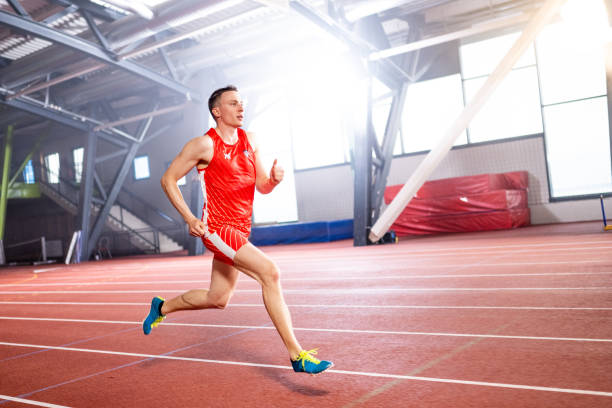 Athlete young man running on sports track during practice.