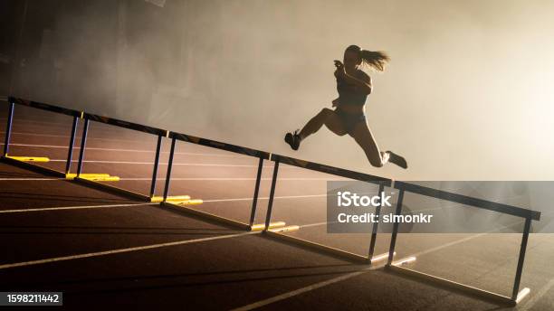 Athlete Jumping Over Hurdle Stock Photo - Download Image Now - Sports Race, Running, One Woman Only