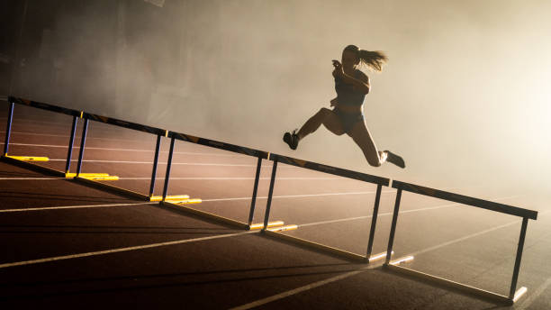 atleta saltando sobre obstáculo - hurdle competition hurdling vitality - fotografias e filmes do acervo