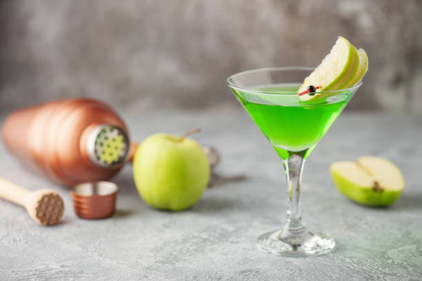 koktajl alkoholowy martini jabłkowy lub zielone kwaśne appletini w kieliszku do martini. narzędzia barowe. - apple martini zdjęcia i obrazy z banku zdjęć