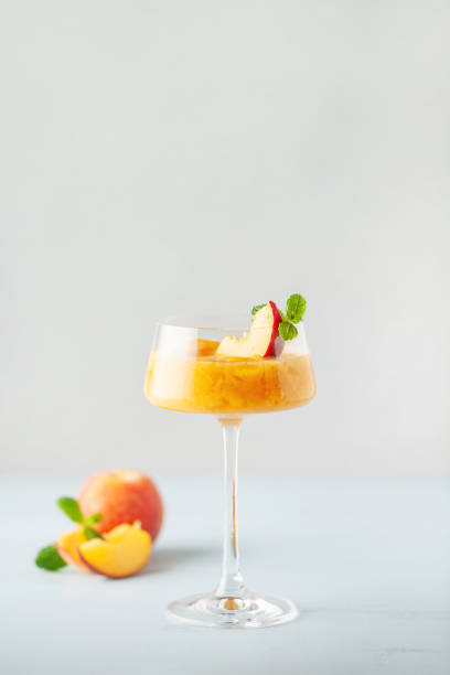 cocktail bellini alla pesca ghiacciata. bevanda alcolica fredda estiva - cobbler peach dessert fruit foto e immagini stock