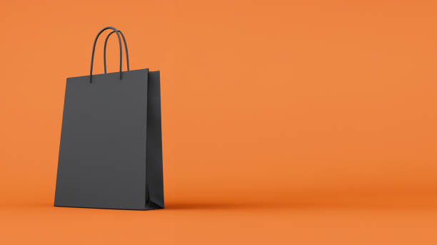 주황색 배경에 검은색 쇼핑 가방 - shopping bag orange bag handle 뉴스 사진 이미지