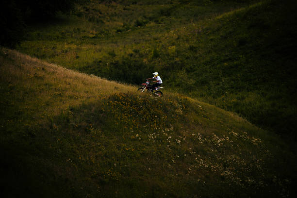 Mountain biker flies over a dirt jump. Slight motion blur indicating speed of action. High dynamic range photo.