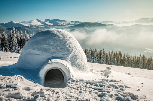 Real snow igloo in sunny winter mountains. Travel theme