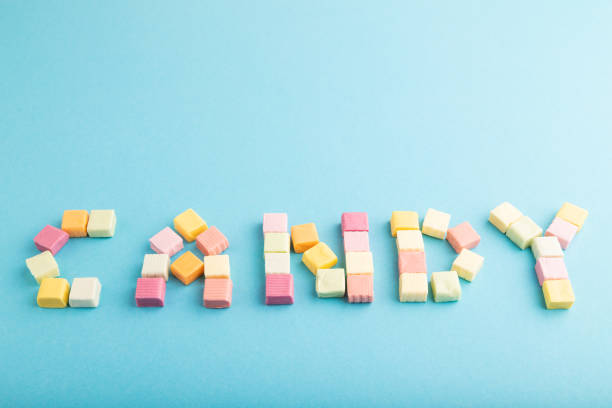 istock The inscription candy laid out with fruit chewing candies on blue pastel, side view, copy space 1598290064