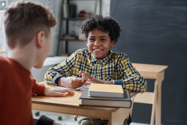 istock Schoolboy talking to his classmate at lesson 1598303450