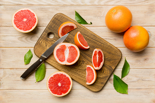 fresh Fruit grapefruit slices on colored background. Top view. Copy Space. creative summer concept. Half of citrus in minimal flat lay with copy space.