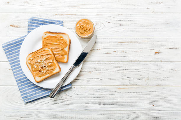 Peanut butter sandwiches or toasts on light table background.Breakfast. Vegetarian food. American cuisine top view vith copy space
