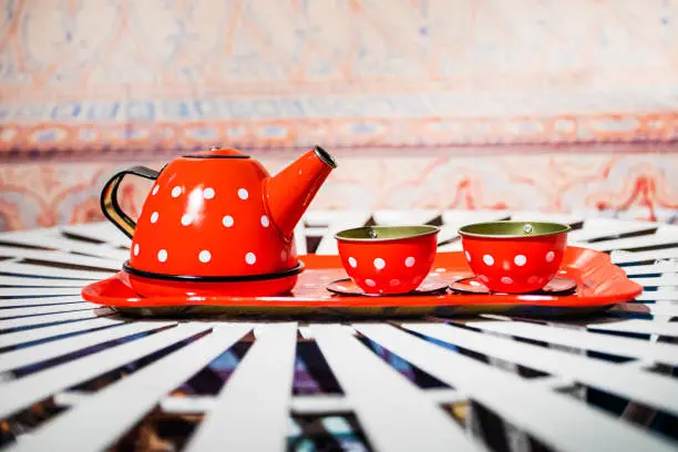 Photo of small children's service with a teapot and two sachets on a tray on the table. socialization skills