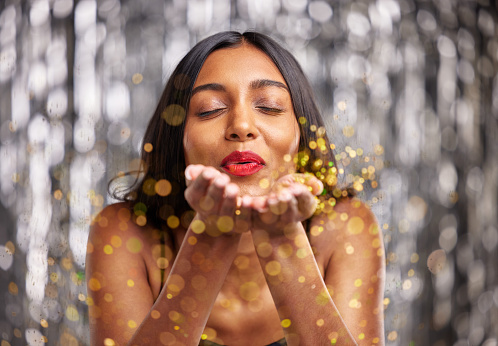 Woman, blow gold glitter and celebration with party and sparkle, bokeh with New Years and festive. Happiness, excited and female person, confetti and anniversary with aesthetic and special event