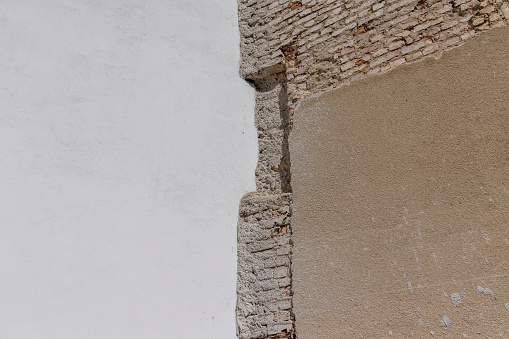 A damaged wall of an ancient building, a part of the wall of a building that eventually collapses from environmental influences