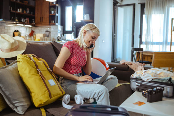 istock Young woman using laptop and preparing for travel 1598369778