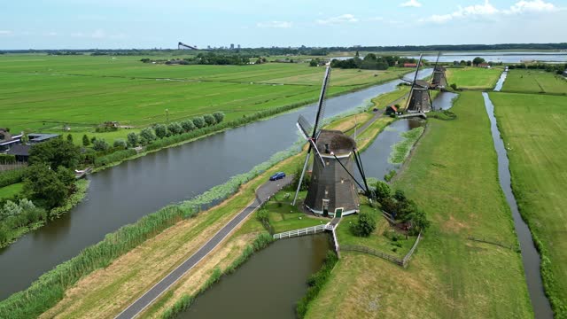 Three windmills on a row, drone point of view.