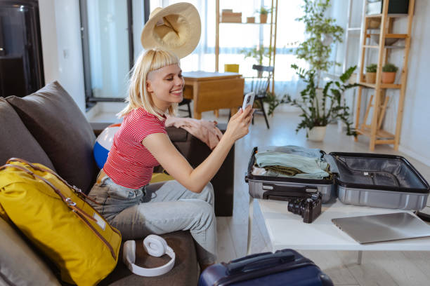 istock Excited young woman taking selfie while packing for a trip 1598376794