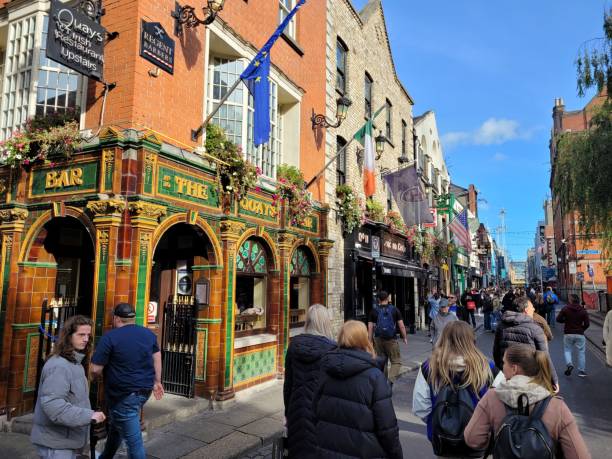 blick auf eine straße voller traditioneller irischer pubs im stadtteil temple bar in dublin, irland - irish culture music guinness pub stock-fotos und bilder