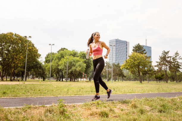 istock Woman jogging outdoors, hydrating 1598400658