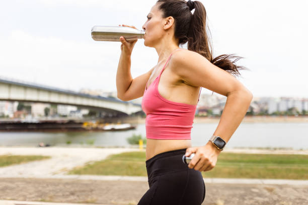 istock Woman jogging outdoors, hydrating 1598408973