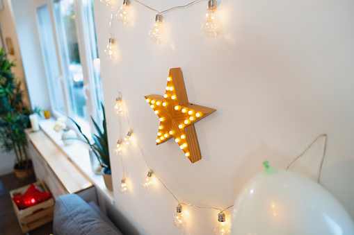 String lights and wooden star shape decoration on the wall
