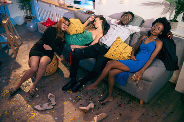 zmęczona wielorasowa grupa ludzi, śpiąca po domowej imprezie - men sleeping african descent shoe zdjęcia i obrazy z banku zdjęć