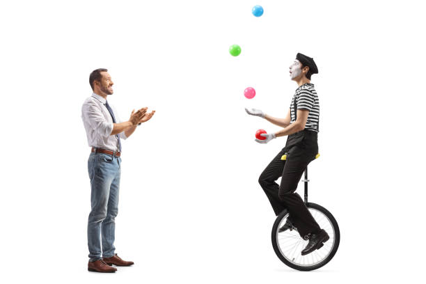 full length profile shot of a man giving an applause to a mime on a unicycle juggling with balls - unicycle men young adult standing imagens e fotografias de stock