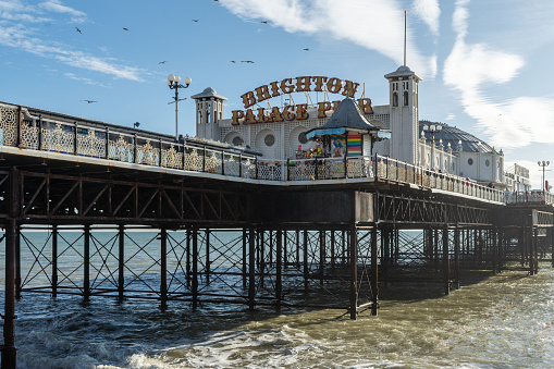 Brighton, UK - November 13th 2022: The sea and pillars underneath Brighton Palace Pier which opened in 1899.