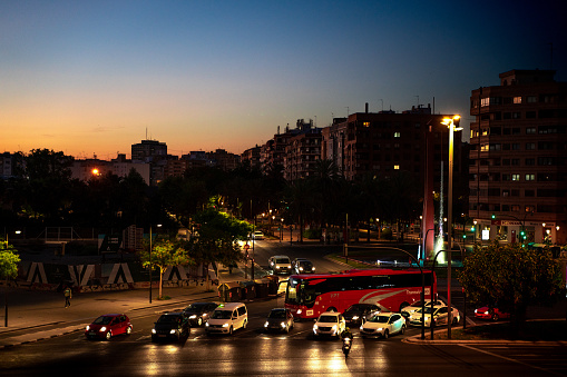 Cars and the red Bus at roundabout in the eveníng traffic of Valencia city, Spain