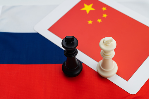 Two chess kings on Chinese and Russian flag.