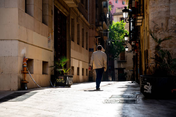 Old man photographed from the back walking on the street of historical center in Valencia