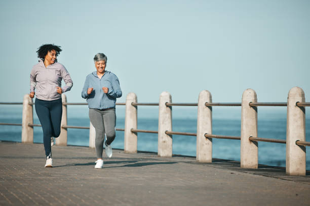 mockup, corsa e donne in spiaggia per il fitness insieme come esercizio mattutino per il benessere e il legame all'aperto. salute, resistenza e persone che si allenano per la maratona a città del capo per l'allenamento sportivo - endurance sport foto e immagini stock