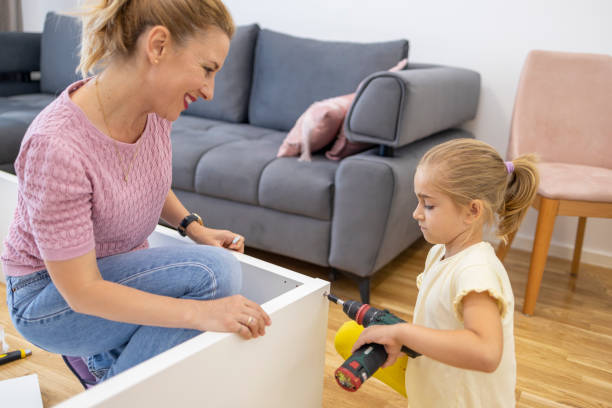 istock Woman assembling furniture using tool and having fun with daughter 1598605763
