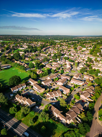 Aerial image taken by drone depicting houses in a residential area - specifically in Crawley, close to Gatwick Airport in West Sussex. The houses are surrounded by lush green trees.