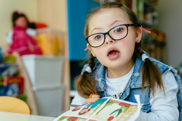 istock A little girl portrait sitting in classroom and performs the task. 1598626422