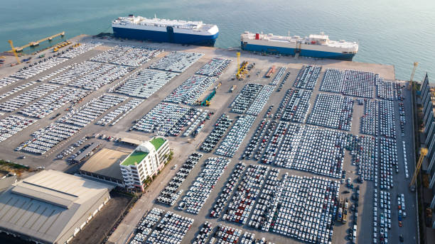 vue aérienne des voitures neuves garées sur le parking de l’usine automobile, en attente de transport roro de l’international, - industrial ship photos photos et images de collection