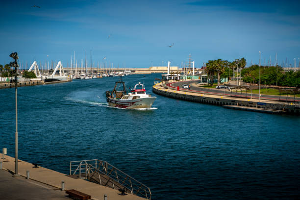 Boat floating in the water canal to the harbor during the sunny day with clear sky