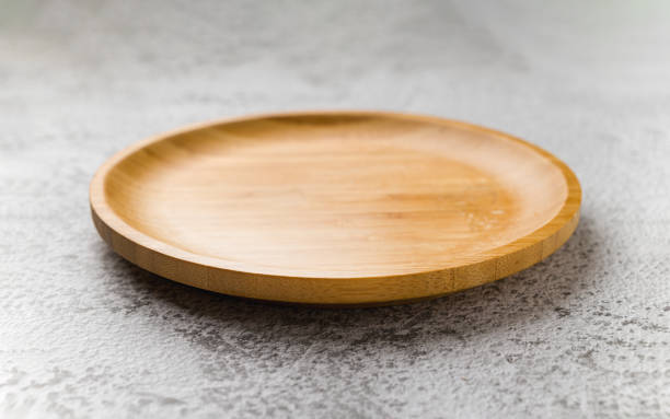istock Wooden plate on a white stone background. handmade cooking utensils 1598651523