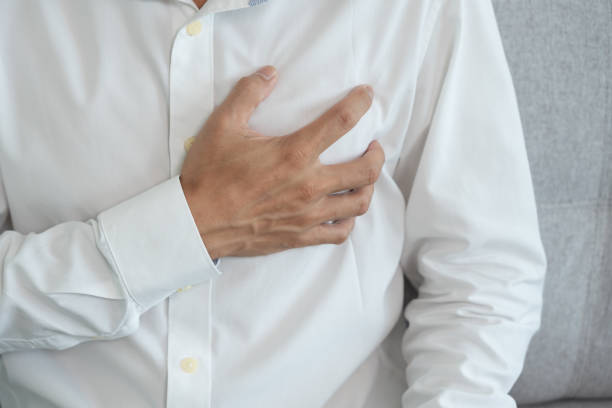 hand hold chest with heart attack symptoms, asian man working hard have chest pain caused by heart disease, leak, dilatation, enlarged coronary heart, press on the chest with a painful expression agarre la mano en el pecho con síntomas de ataque cardíaco, hombre asiático que trabaja duro tiene dolor en el pecho causado por enfermedad cardíaca, fuga, dilatación, agrandamiento del corazón coronario, presión sobre el pecho con una expresión do