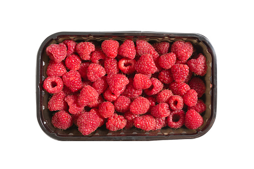 Ripe raspberries in a box on a white background, top view.