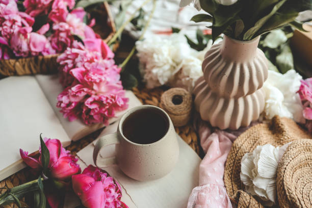 istock Beautiful spring composition, good morning concept. Cup of tea, peonies and open book 1598691375
